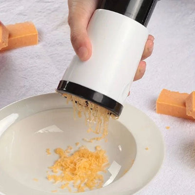 Mise en situation conviviale : râpage de parmesan frais directement sur un plat de pâtes à table.