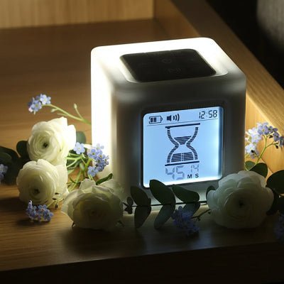 Minuterie cube LED utilisée comme veilleuse apaisante sur une table de chevet