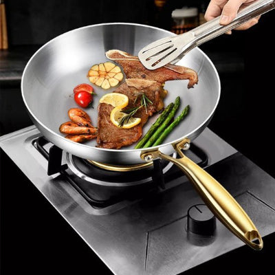 Poêle inox professionnelle HeatPro avec manche doré ergonomique sur plaque à induction